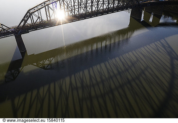 Bridge Casts Long Shadow on River During Sunrise