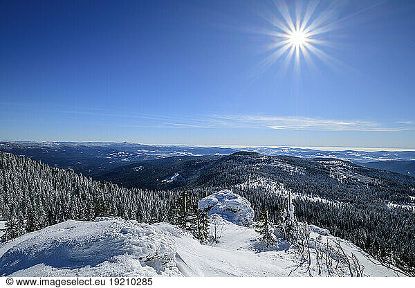 Bright sun shining over snowcapped mountain