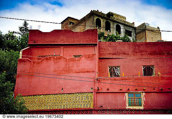 Brightly colored buildings sit near a busy Moroccan road.