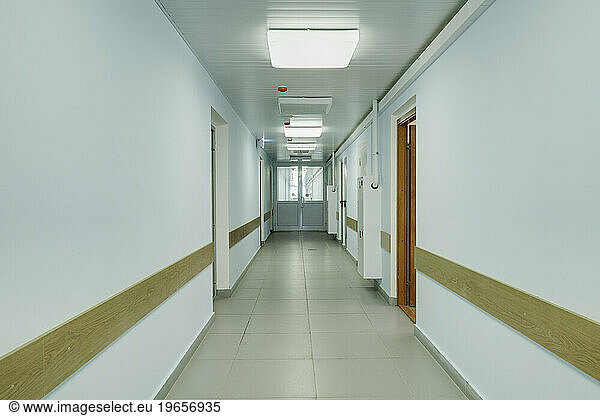 Brightly lit corridor in a sports hall with doors leading off it.