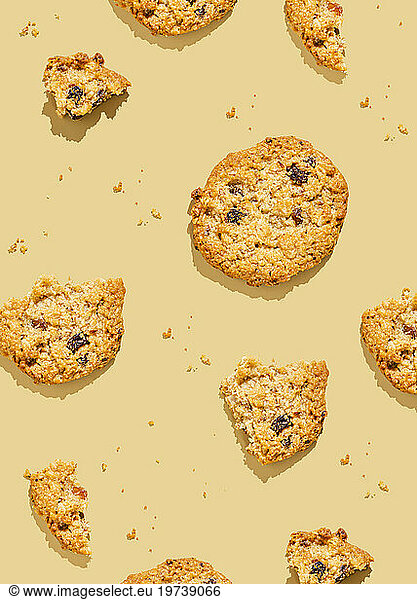 Broken oatmeal cookies arranged against yellow background