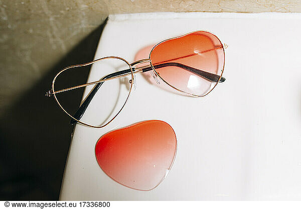 Broken orange heart shape sunglasses on table
