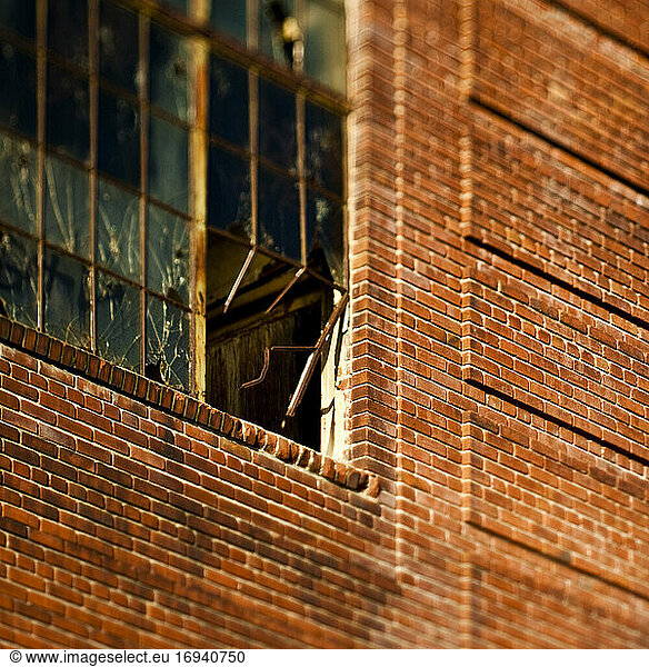 Broken window in brick warehouse.