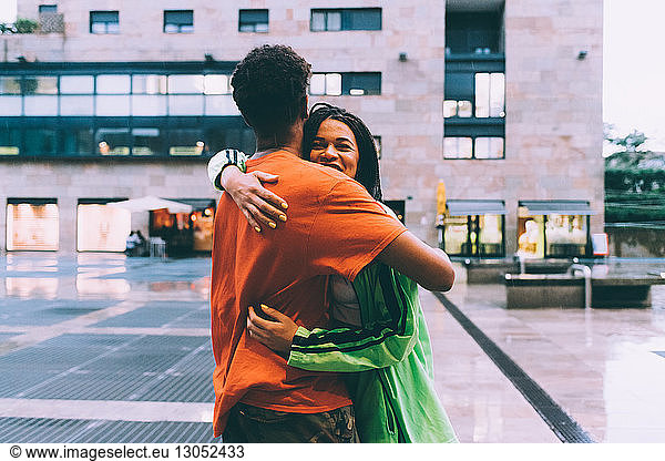 Brother and sister hugging in town square  Milan  Italy