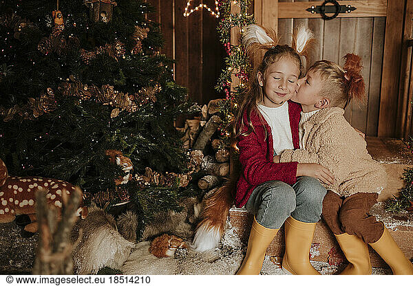 Brother kissing sister's cheek at Christmas