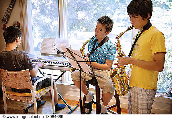 Brothers practicing musical instruments at home