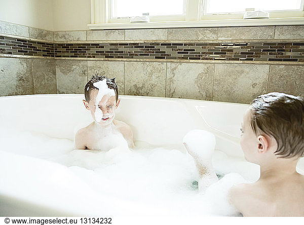 Brothers taking bath together in bathtub