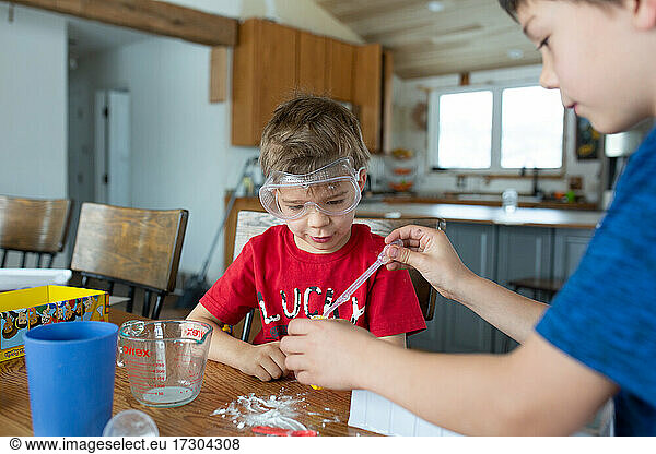 Brothers working together on science experiment at home