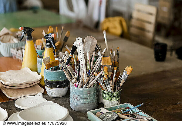 Brushes and ceramic plates on workbench at art studio