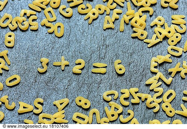 Buchstabennudeln bilden Rechenaufgabe  Mathematik
