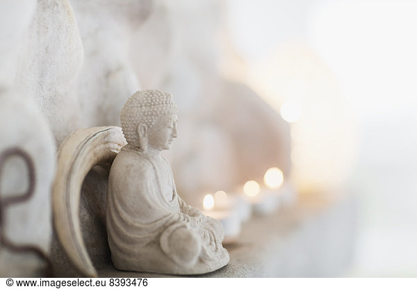 Buddha-Figur und Kerzen auf dem Sims