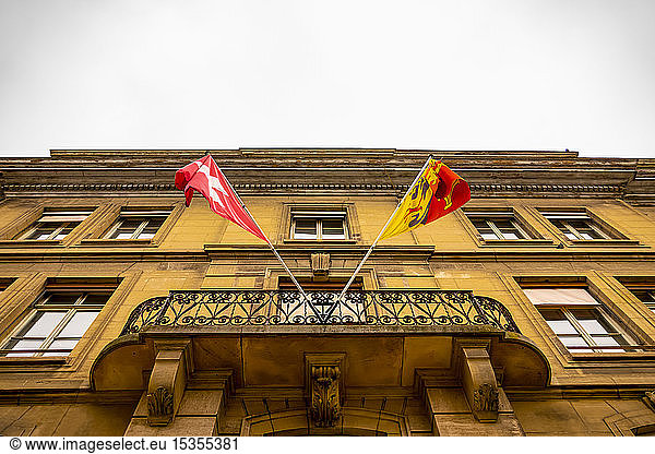 Building facade and balcony with flags of Switzerland and Geneva; Geneva  Geneva  Switzerland