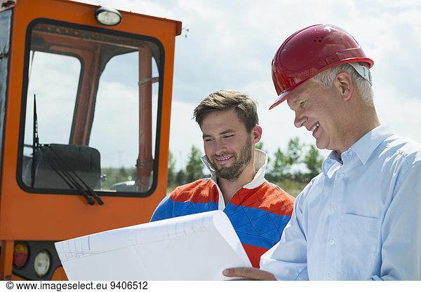 Building owner and construction worker discussing construction plan