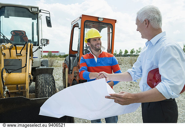Building owner and construction worker discussing construction plan