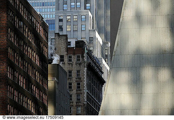 Buildings in New York City  view from below  historic and modern architecture  shadows and sunlight