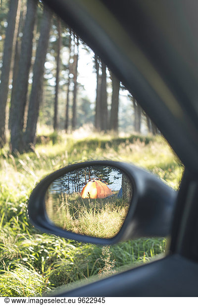 Bulgaria  Car in the woods  reflection of tent in the wing mirror