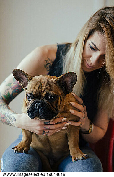 Bulldog poses with a tattooed girl.