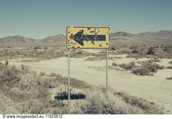 Bullet riddled arrow sign in desert  Black Rock Desert  Nevada