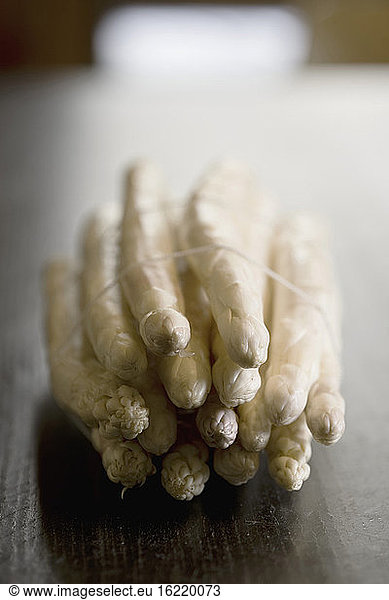 Bundle of white asparagus on wooden table  close up