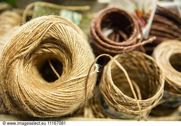 Bundles of twine  coloured string and natural hessian twine on a workbench.