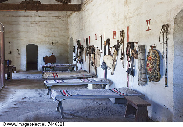 Bunkhouse or sleeping room with cots and riding tack and personal belongings of Spanish at Mission La Purisima State Historic Park  Lompoc  California  Founded in 1787  the eleventh mission of the twenty-one Spanish Missions established in California