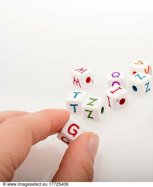 Buntes Alphabet Buchstabenwürfel in der Hand auf einem weißen Hintergrund
