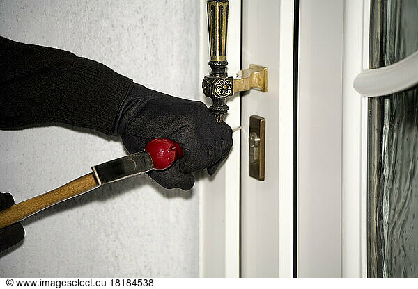 Burglary hand with gloves on door  close-up