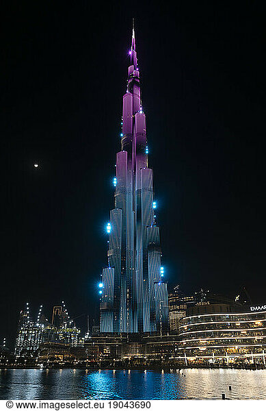 Burj Khalifa at night with lights and moon in the background