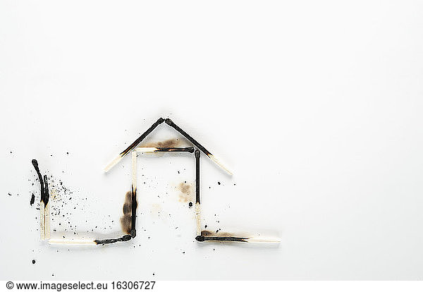Burnt down matches shaped like a house