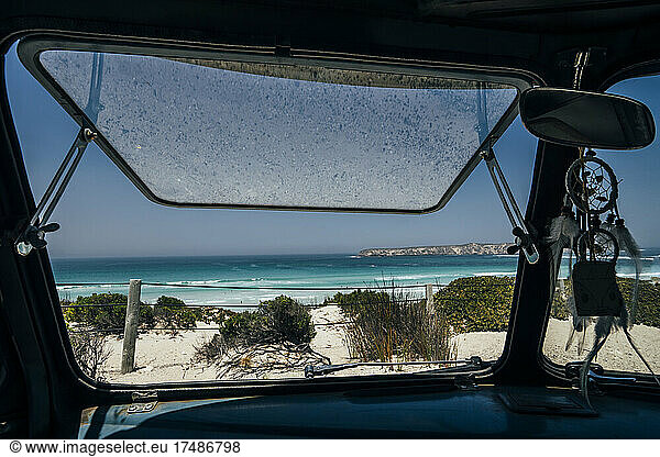 Bus window open to sunny scenic idyllic ocean seascape