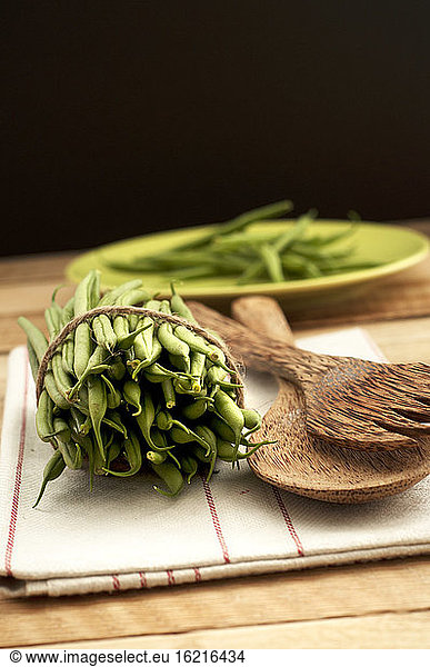 Bush beans with wooden spoon and napkin on wooden table  close up