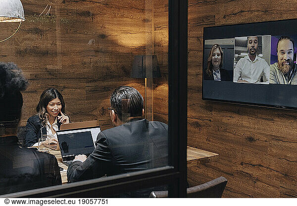 Business colleagues discussing through video conference in board room during meeting