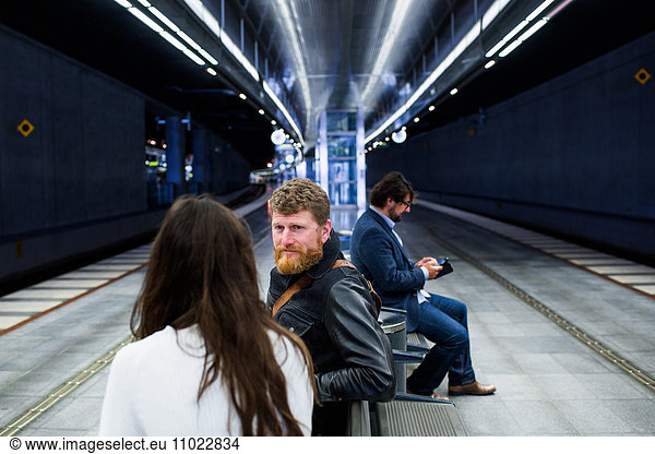 Business colleagues discussing while sitting at subway station
