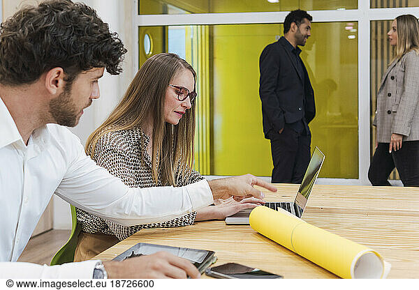 Business colleagues in office working together on laptop