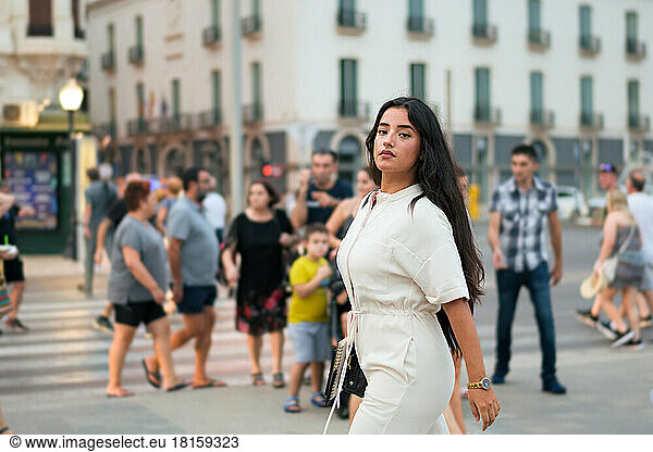 Business Latin Woman schaut in die Kamera umgeben von Menschen