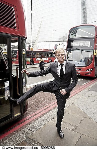 Business man between buses in London  UK.