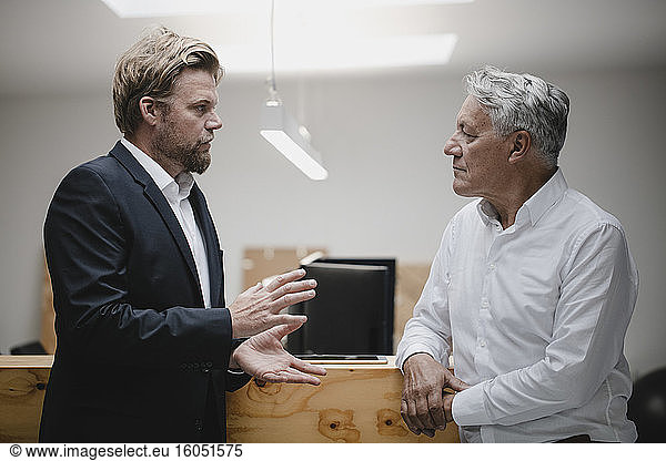 Business partners standing in office  talking