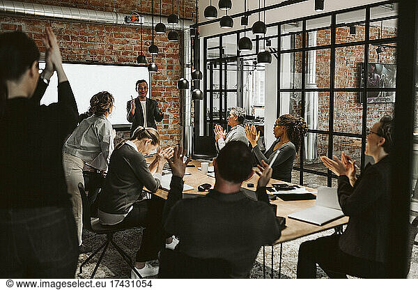 Business people applauding during meeting in board room