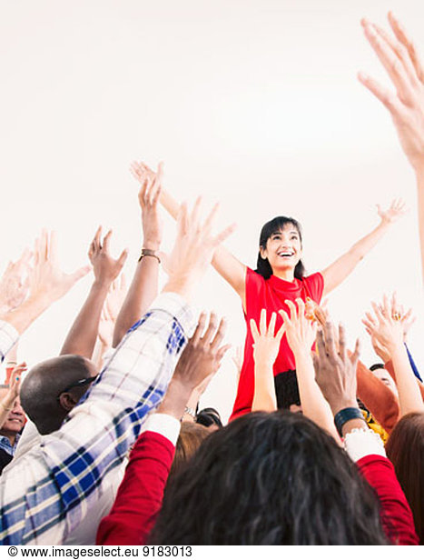 Business people cheering for businesswoman