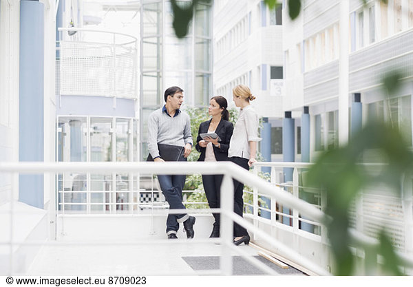 Business people communicating at office balcony