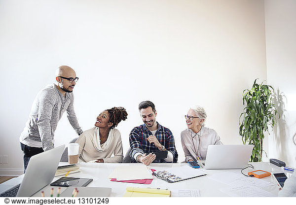 Business people discussing on table in board room at office