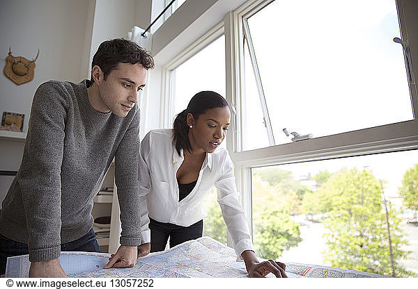 Business people discussing over map in creative office