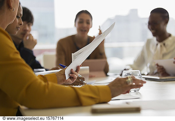 Business people discussing paperwork in conference room meeting