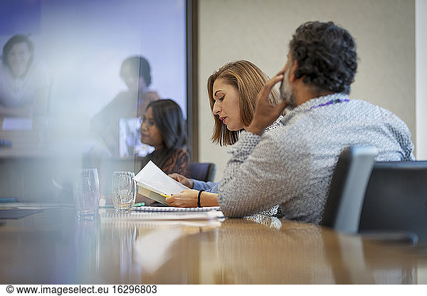 Business people discussing paperwork in conference room meeting