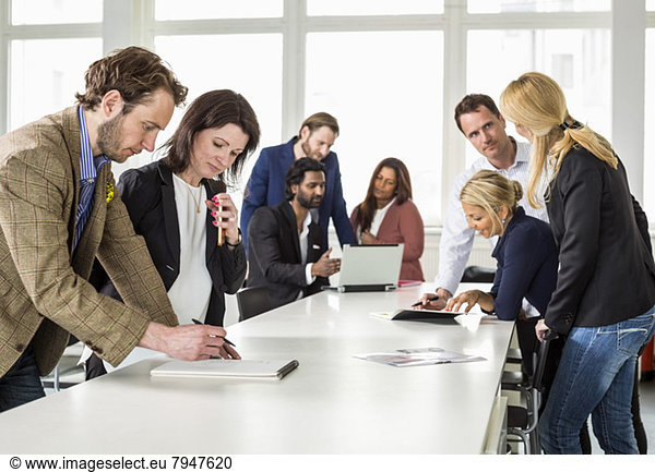 Business people discussing while working at desk in office