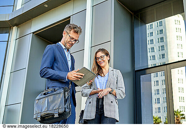 Business people dressed in formal wear meeting in front of the office