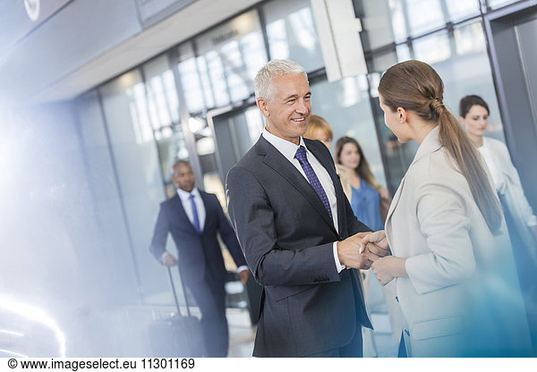 Business people greeting shaking hands in airport