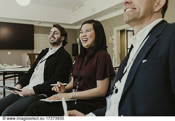 Business people laughing in discussion during meeting at education class