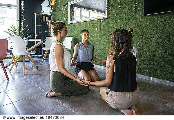 Business people meditating at workplace in break time