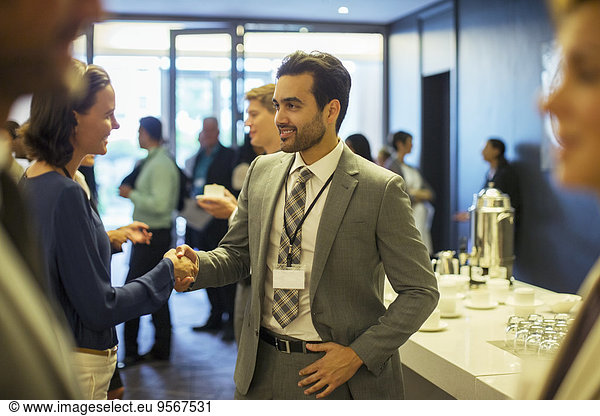 Business people shaking hands during reception in office